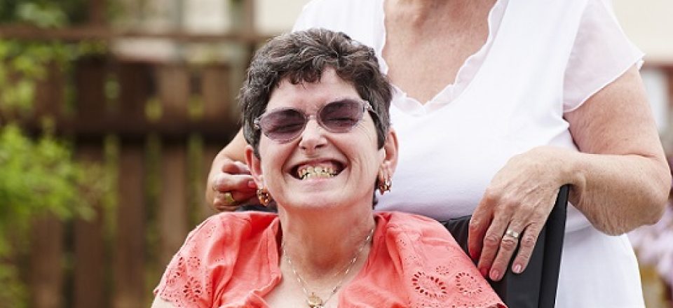 disabled woman in a wheelchair with her carer mother in garden