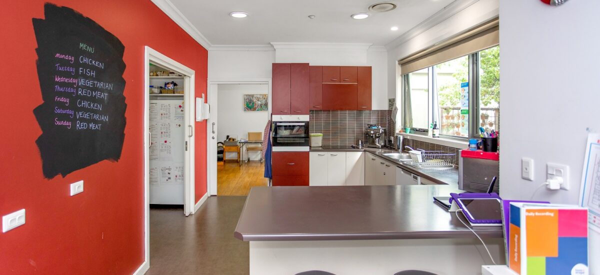 Kithcen with a red feature wall and a breakfast bench