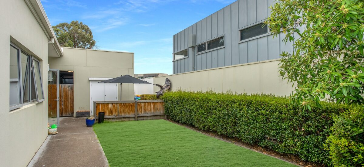 Lawn area with green shrubbery and paved path