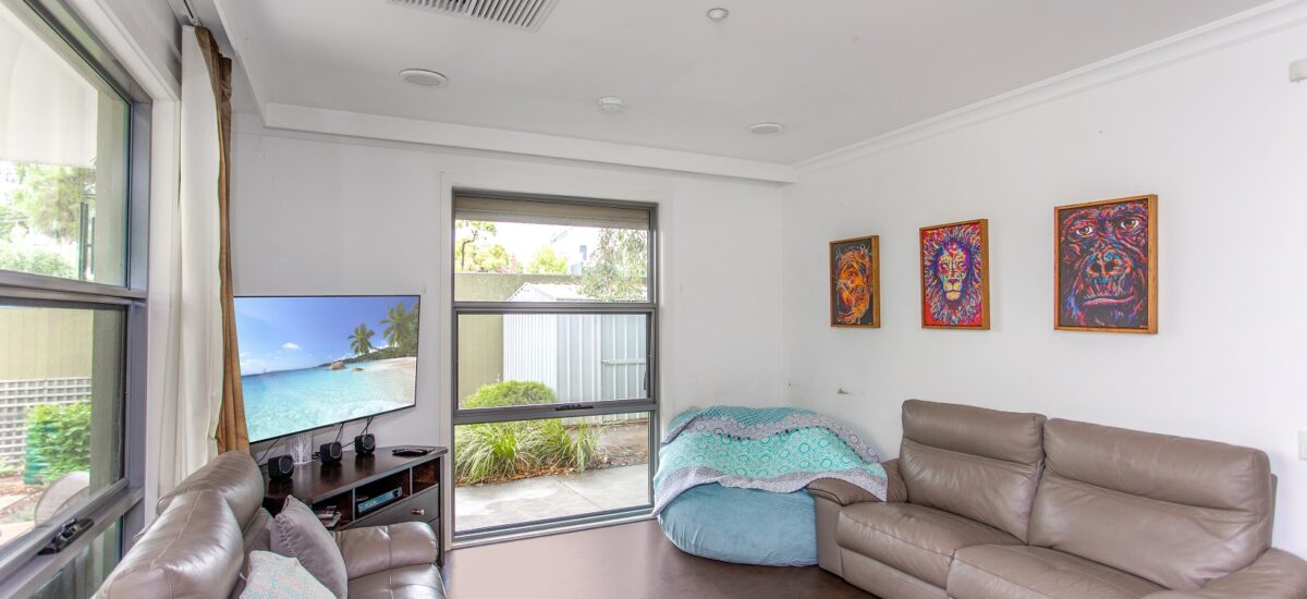 Living area of an SDA home with two sofas, artwork and a TV